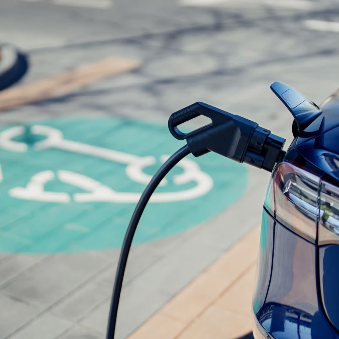 Electric vehicle charging cable plugged in at a charging bay